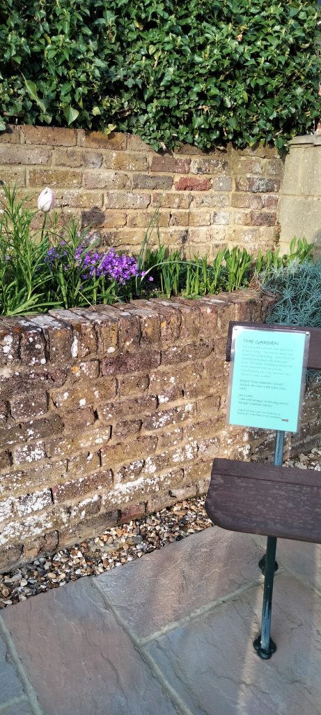 Prayer station in the Link-up garden, a bench and flower bed.